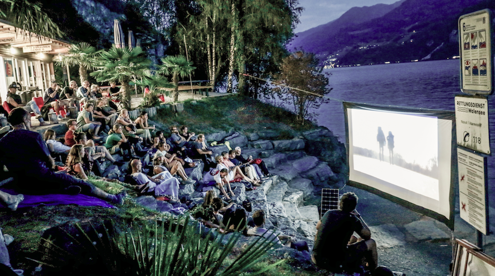 Open-Air-Kino am See mit Besuchern auf Treppenstufen