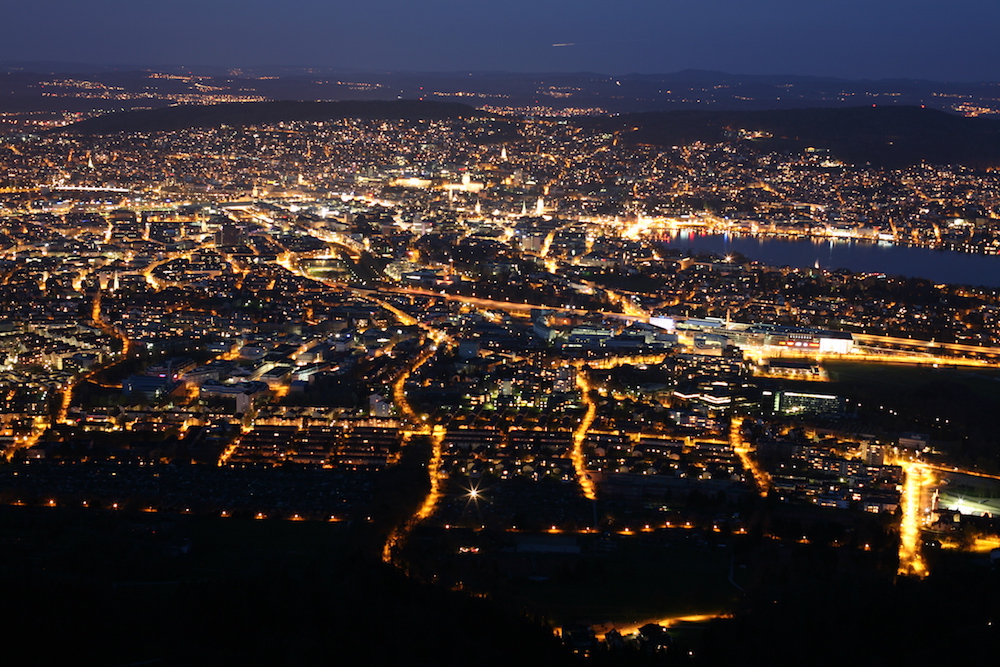 Blick auf Zürich bei Nacht mit vielen Lichtern